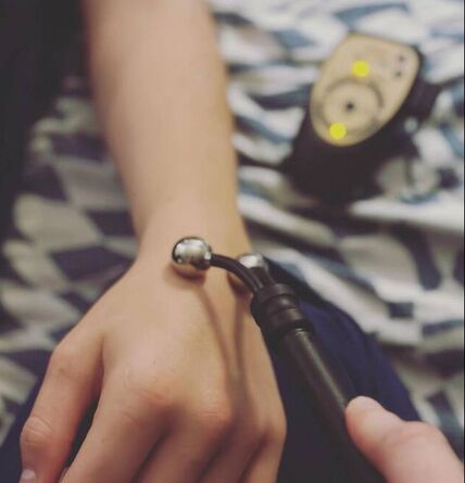 Hand using Avazzia device on another hand.