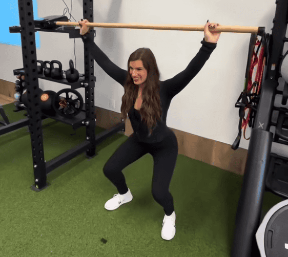 Woman doing overhead squat in gym